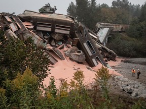 Officials stands near the wreckage of a train carrying potash that derailed near Hope, B.C,, on Monday, September 14, 2020. CN Rail says at least 20 rail cars carrying potash derailed today near Hope, B.C.The company says no injuries, fires or dangerous goods are involved.