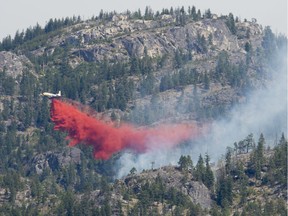 A air tanker drops fire retardant on the Christie Mountain wildfire along Skaha Lake in Penticton, B.C. Thursday, Aug. 20, 2020. Evacuation alerts have now been lifted for the only remaining properties in British Columbia still affected by a wildfire.