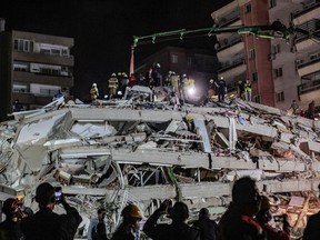 Rescuers search for survivors at a collapsed building after a powerful earthquake struck Turkey's western coast and parts of Greece, in Izmir, on Oct. 30, 2020.
