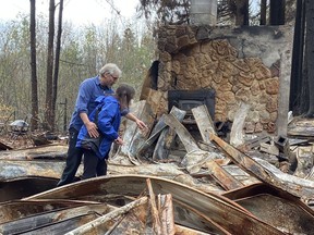 Troy Kirk and Maria Winwood search for salvageable possessions in the wreckage of their house in Detroit, Ore., which was levelled by wildfires last month. The couple escaped just before the fire raced through the town.