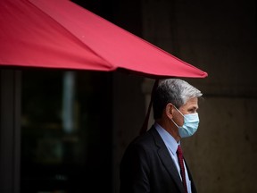 Liberal Leader Andrew Wilkinson stands under a patio umbrella during a campaign stop at a cafe in Coquitlam.
