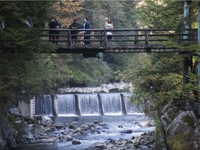 Friends of a man who died after being swept away by a huge surge of water that had been released from the Cleveland Dam on the Capilano River line a bridge, south of the Capilano Fish Hatchery in North Vancouver, on Oct. 2. Several other fishermen were rescued after the surge of water.