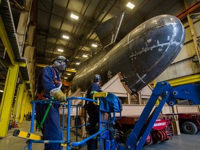 Workers prepare the 100-tonne ‘bulbous nose’ bow for a navy ship to be wheeled out the door of Ideal Welders on Annacis Island on Tuesday. The ship’s bow will be barged to the North Shore starting Wednesday.