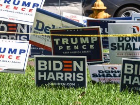 Trump-Pence and Biden-Harris signs are displayed outside The Coral Gables Branch Library in Miami, Florida on October 27, 2020.