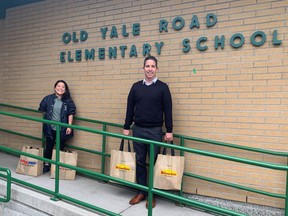 Old Yale Road Elementary principal Joe Leibovitch and outreach worker Victoria Tecson carrying supplies of food to feed families over the weekend.