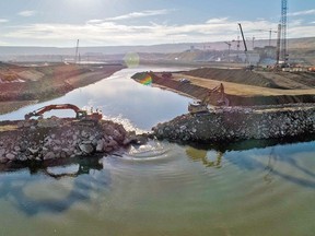 On October 3, 2020, the final rock materials were placed to complete the rockfill berm, starting full diversion of the Peace River. Image of progress on construction of the B.C. Hydro Site C power project/dam.