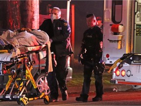 A Metro Vancouver Transit Police officer is loaded into an ambulance following a two-vehicle collision Wednesday night in Surrey.