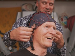 Dr. Ryan D'Arcy, neuroscientist, helps Canadian veteran Trevor Greene with the NeuroCatch Platform brain monitoring device as part of his ongoing physiotherapy rehabilitation.