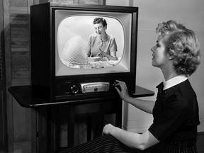 A woman watches a TV in the early 1950s.