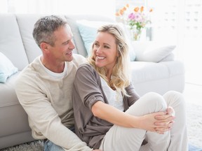 Happy casual couple sitting on rug