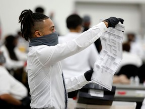 Election workers work on counting absentee ballots for the 2020 general election at TCF Center in Detroit, Michigan.