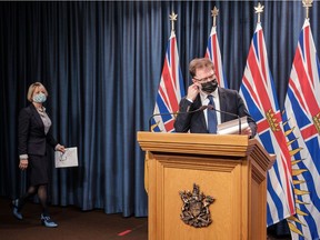 Health Minister Adrian Dix and Chief Provincial Health Officer Dr. Bonnie Henry mask up before providing an update on COVID-19 on Thursday in Victoria.