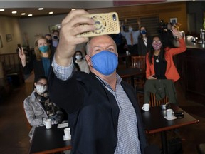 Premier-elect John Horgan takes a selfie with his mask as he attends a campaign stop in New Westminster on Oct. 23. Since the snap election, COVID-19 has been a big problem in the Lower Mainland.