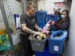 Diane Waters, left, coordinator of Charlie's community pet resources, and Kim Monteith, manager of animal behaviour and welfare at the B.C. SPCA, sort through donated items at the SPCA in Vancouver on Nov. 26.