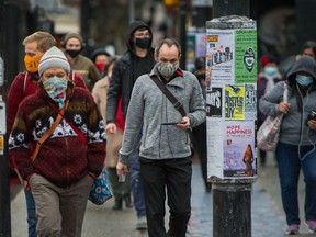 People wear masks near Commercial and Broadway SkyTrain Station in Vancouver.