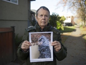 Roz Bell holds a photo of her missing dog Bailey on Dec. 1, 2020. She believes her dog was stolen while they were walking in Strathcona Community Garden in July and is pleading for the YorkiePoo's return.