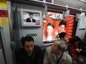 File photo: A passenger watches a television screen showing Chinese Vice President Vice Xi Jinping delivering a speech, on a subway train in Shanghai.