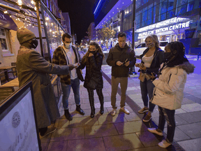 A doorman checks the identification of patrons before letting them enter a restaurant in Halifax.