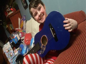 Nine-year-old Charlie Macklin with his guitar from the "Steveston Elf" on Christmas morning.