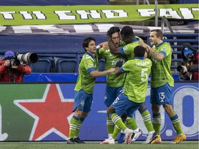 Seattle Sounders FC defender Shane O'Neill (second from right) celebrates on Tuesday with midfielder Nicolas Lodeiro and forward Jordan Morris after scoring a goal against FC Dallas at Lumen Field in Seattle.