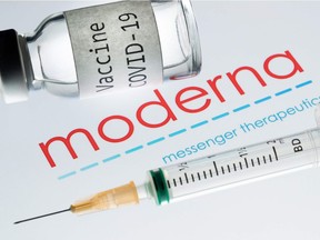 This file photo taken on November 18, 2020 shows a syringe and a bottle reading "Vaccine Covid-19" next to the Moderna biotech company logo.