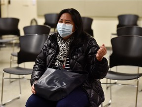 A health care worker shakes her arm in the recovery area after being one the first people to be injected with a dose of the Pfizer-BioNTEch COVID-19 vaccine in Vancouver.