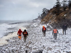 Members of a ground search and rescue team walk along the shore of the Bay of Fundy in Hillsburn, N.S. as they continue to look for five fishermen missing after the scallop dragger Chief William Saulis sank in the Bay of Fundy, on Wednesday, Dec. 16, 2020.