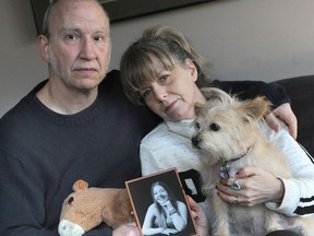 Chris and Hollie Hall with a picture of their late daughter Lily Hall, joined by Lily's dog Lita.
