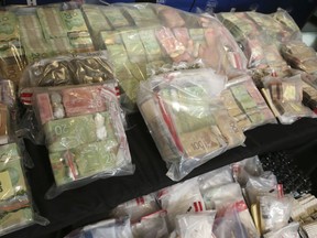 Peel Regional Police Specialized Enforcement Bureau spent 14 months to take down an organized GTA crime group known as "New Money Suh Sick" gang arresting 88 people. The gang is involved in multiple homicides, multiple shootings, drug and human trafficking, and money laundering (Pictured) Large amounts of cash that was confiscated during raids on Wednesday November 18, 2020. Jack Boland/Toronto Sun/Postmedia Network