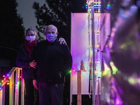 Mary Lou Baldwin and Paul Funston pose for a photo with their trailer in Fort Langley, B.C., Friday, December 18, 2020. The duo would normally spend the winter south of the border, but with the Canada-U.S border closed due to the COVID-19 pandemic, they are spending it at a campground in southern B.C.