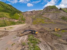 The two slides, in 2018 and last June, have cut off the only road to the rural community and two homes above the community and some in Old Fort remain under evacuation alert, said the residents' lawyer. He accuses the government of "sticking it to hard-working families" whose properties are now worthless. Crews construct a temporary access road to bypass part of the main road into Old Fort which was cut by landslides.