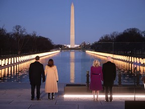 Left to right: Douglas Emhoff, U.S. Vice President-elect Kamala Harris, Dr. Jill Biden and U.S. President-elect Joe Biden look down the National Mall as lamps are lit to honour the 400,000 American victims of the coronavirus pandemic at the Lincoln Memorial Reflecting Pool on Jan. 19, 2021 in Washington.