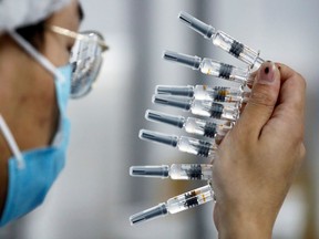 A worker performs a quality check in the packaging facility of Chinese vaccine maker Sinovac Biotech, developing an experimental coronavirus disease (COVID-19) vaccine, during a government-organized media tour in Beijing, China, September 24, 2020.