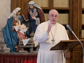 This handout photo taken and released on Friday, Jan. 1, 2021 by the Vatican Media shows Pope Francis holding a weekly live-streamed private audience in the library of the apostolic palace in The Vatican.