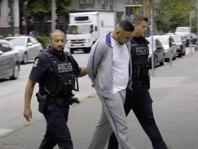 Gary Kang is pictured being escorted by two Vancouver police officers on Aug. 7, 2018.