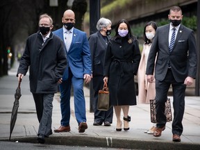 Meng Wanzhou (centre, in black coat carrying purse) chief financial officer of Huawei, leaves B.C. Supreme Court during a break from court hearing in Vancouver on Jan. 12, 2021.