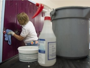 A cleaner wipes down students lockers at Eric Hamber Secondary school in Vancouver, B.C. Monday, March 23, 2020.