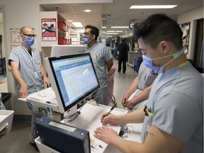 A health-care team does morning rounds in the COVID-19 intensive care unit at St. Paul's hospital in downtown Vancouver, Tuesday, April 21, 2020.