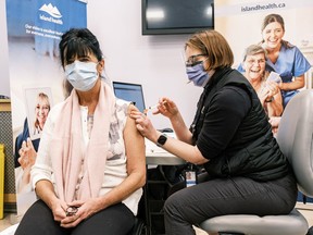 A worker with Island Health receives her first dose of the Pfizer-BioNTech vaccine.