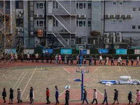 People line up to get their nucleic acid test on the sports ground of a school following the outbreak of the coronavirus disease (COVID-19) in Beijing, China, January 22, 2021.