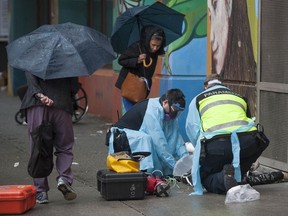 Paramedics help a man suffering a drug overdose on Columbia Street in Vancouver's Downtown Eastside.