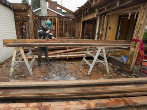 Unbuilders Reconstruction's Niall Todd removes nails from a board at a house in North Vancouver in December 2018. The company demolishes homes by-hand and repurposes the reclaimed building materials.