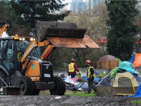 City of Vancouver work crews clean up garbage left by campers at the homeless camp at Strathcona Park in Vancouver.