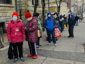 People line up the COVID-19 vaccination clinic in Vancouver's Downtown Eastside on Friday. The clinic is for those that are homeless, or living in a shelter, or living in an SRO, or living in supportive housing.