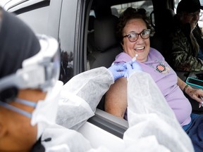 Barbara Johnson smiles while receiving the Pfizer-BioNTech COVID-19 vaccine at a drive-through COVID-19 vaccination site at the Strawberry Festival Fairgrounds in Plant City, Florida, U.S. January 13, 2021.