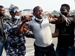 Police officers arrest a protestor during a demonstration against police brutality, at the Lekki tollgate in Lagos on February 13, 2021.