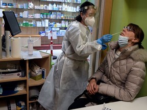 A pharmacist administers COVID-19 rapid test at a Madrid, Spain, drugstore.