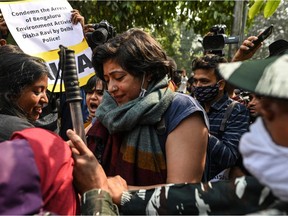 Police personnel stop demonstrators as they try to cross police barricades during a protest against the arrest of climate change activist Disha Ravi by Delhi police for allegedly helping to create a guide for anti-government farmers protests shared by environmentalist Greta Thunberg, outside the Delhi Police headquarters, in New Delhi on February 16, 2021.