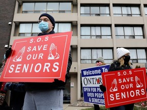 Protesters stand outside a long term care home during a rally to demand the facility invest more on resident care and staff safety during the pandemic.