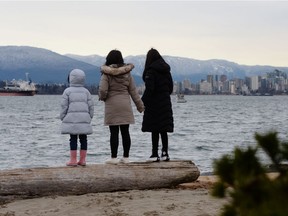 Maria Law, who emigrated from Hong Kong with her family, views the skyline with her daughters from Jericho Beach in Vancouver, British Columbia, Canada January 26, 2021.